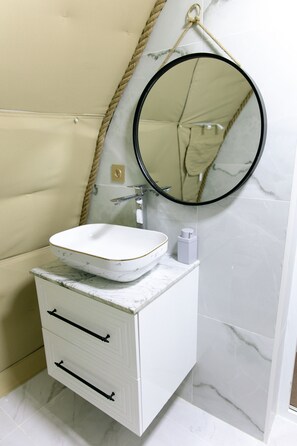 A bathroom with a white vanity, a round mirror, and a marble countertop. - Glamping Dream Domes Ismayilli (Ismailli)