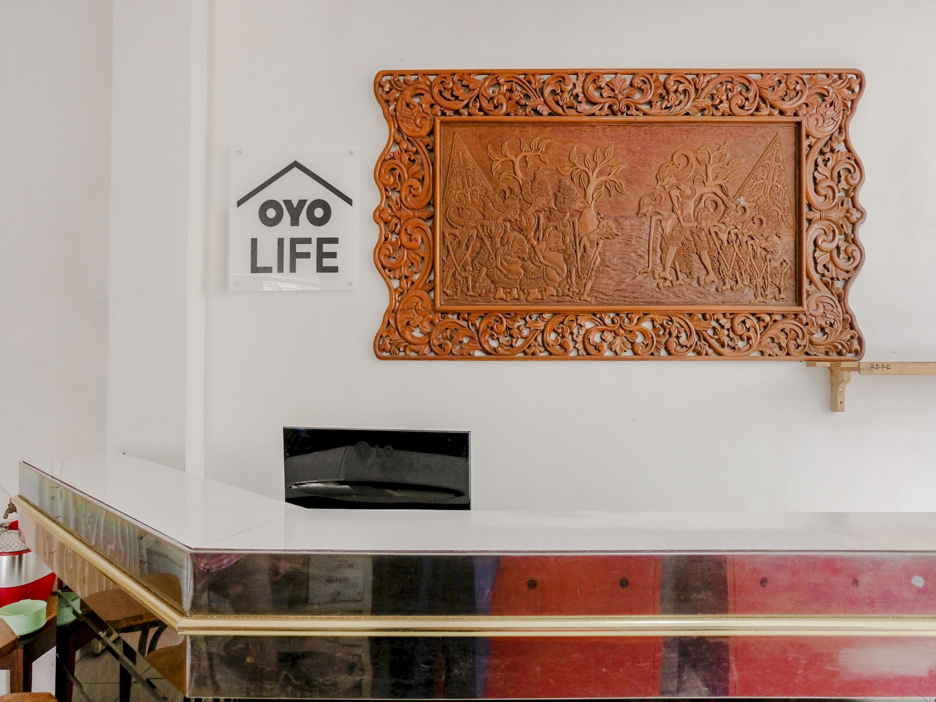 A wall with a sign reading "OYO LIFE" and a decorative wooden carving.