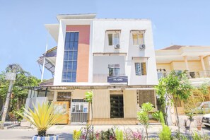 Experience the sleek, modern architecture of OYO LITE, surrounded by lush greenery.