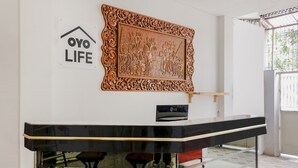 A modern interior with a bar area, a decorative wooden carving, and a sign reading "OYO LIFE". - OYO Life 2760 Kost Simpang Borobudur 47 (Malang)