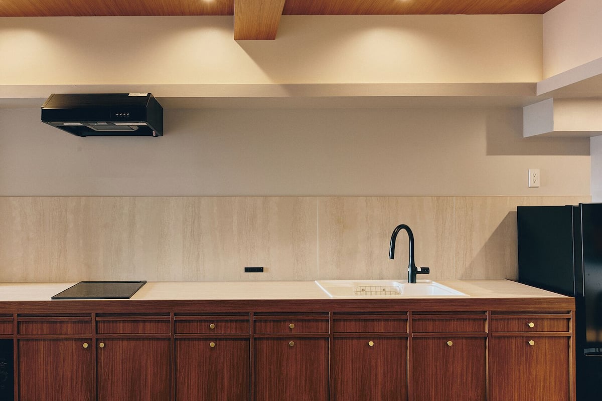 Una cocina moderna con estufa integrada, lavaplatos y armarios de madera.
