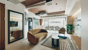 Een moderne woonkamer met een bank, een salontafel en een eethoek met stoelen.
