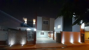 Una casa moderna con un cancello d'ingresso, un vialetto coperto e un garage ben visibile.
