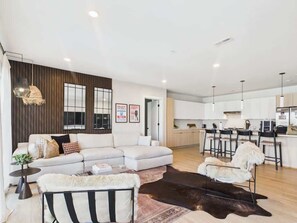 A modern living room with a sectional sofa, a coffee table, and a rug. - Hyve - The Last Rodeo - In SoBro -Walk to Broadway (Nashville)