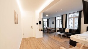 A modern living room with a sofa, a coffee table, and a dining area with a table and chairs.