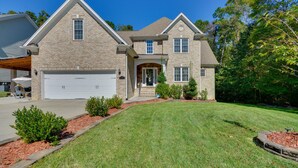 A two-story house with a garage, a front porch, and a well-maintained lawn. - High Point Vacation Rental w/ Private Deck! (High Point)