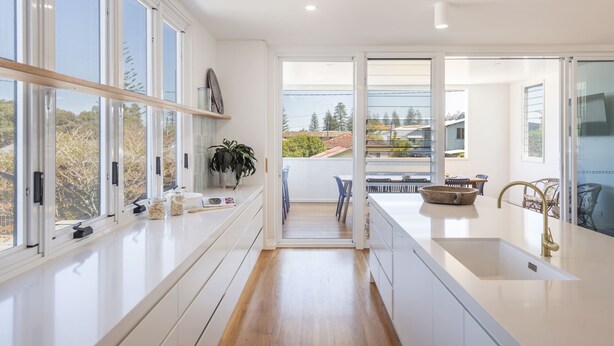 A modern kitchen with large windows, a wooden floor, and a view of the outdoors. - Sandhurst - Oceanstays (Yamba)