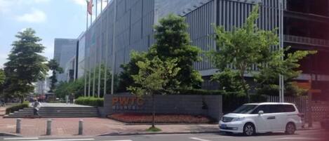 A modern building with a sign reading 'PWTC' and a white van parked in front.