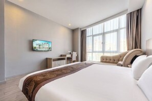 A hotel room with a large bed, a desk, a chair, and a TV on the wall. - Tingyue Yiju Hotel (Shanghai)