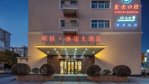 A hotel entrance with a sign for 'XINCHI DENTAL' and a 2F entrance sign. - Tingyue Yiju Hotel (Shanghai)