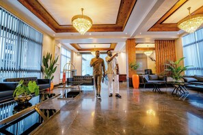 Un hall d’entrée spacieux, doté d’un sol en marbre poli, de meubles modernes et d’élégants lustres.