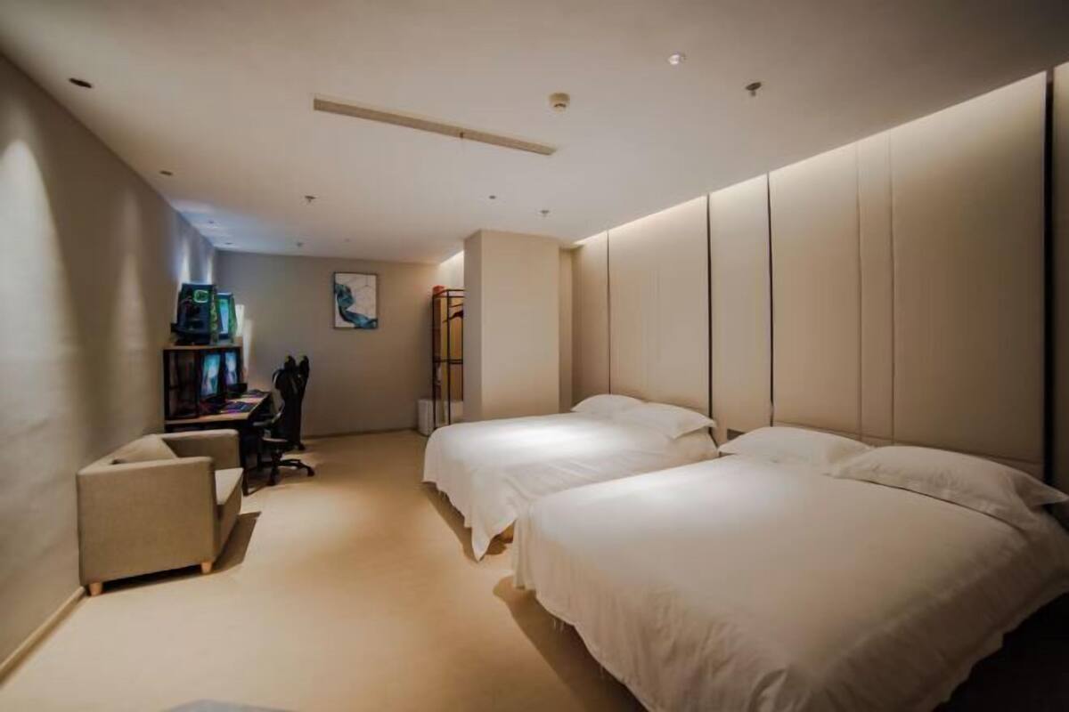 Habitación de hotel con dos camas, un escritorio y una silla.