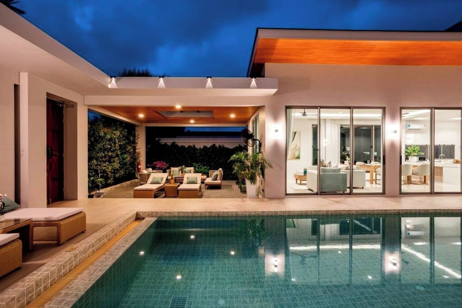 Una casa moderna con piscina, area salotto esterna e interni luminosi.