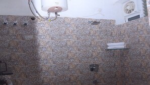 Ein Badezimmer mit Toilette, Dusche und Warmwasserbereiter.