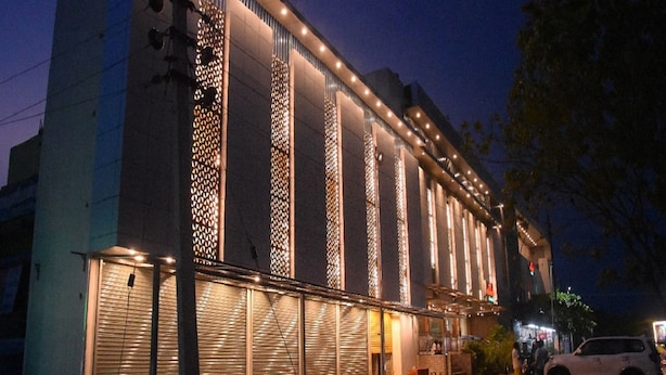 Ein Gebäude mit moderner Fassade, das vertikale Musterfelder und beleuchtete Fenster aufweist.