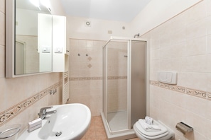 A bathroom with a sink, toilet, and shower.
