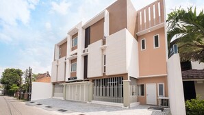 A modern multi-story residential building with a flat roof, large windows, and a gated entrance. - OYO Life 2801 Sari Panguripan (Kos Putri & Pasutri) (Depok)