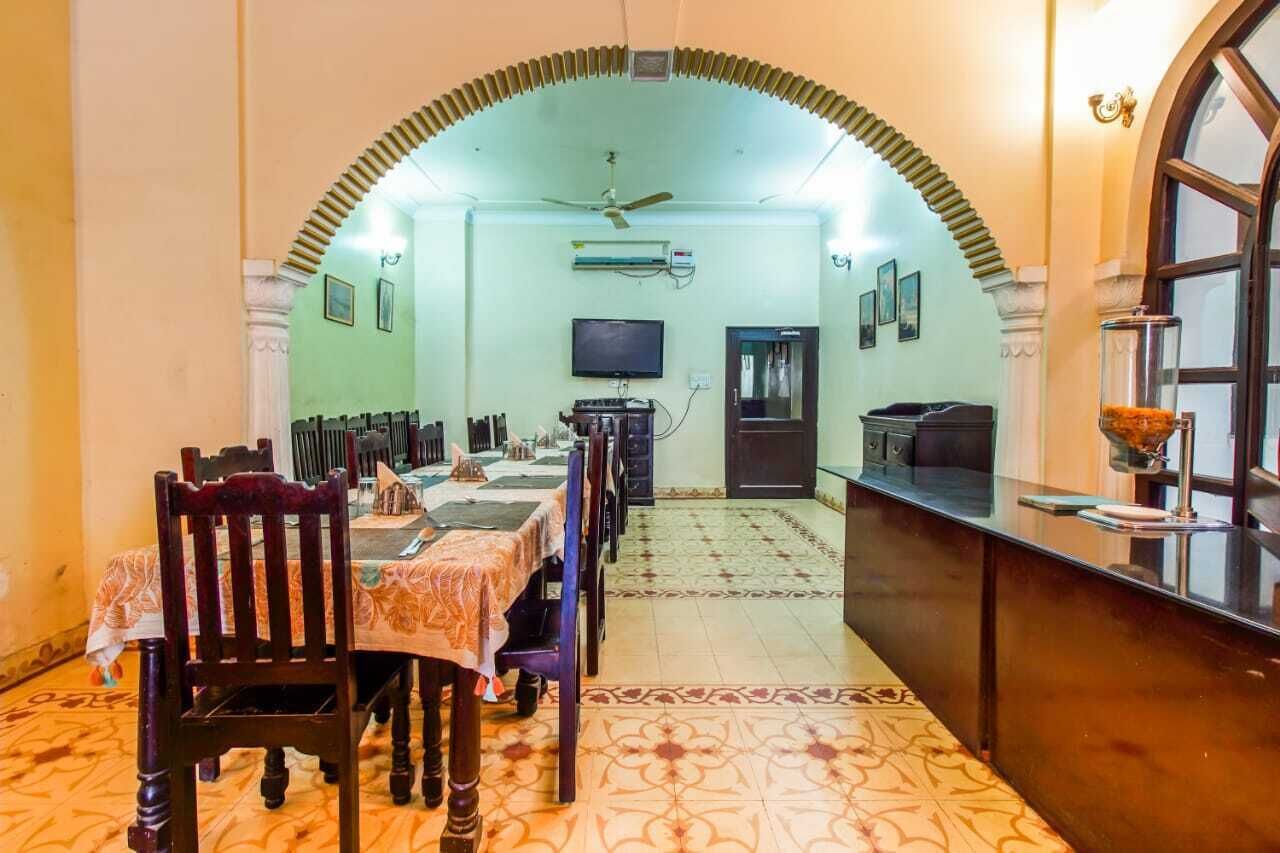 A dining area with a long table, chairs, and a TV mounted on the wall.
