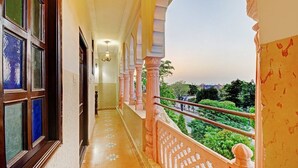 Un couloir avec un balcon donnant sur un jardin.