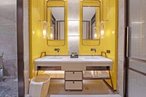 Ein Badezimmer mit einem Doppelwaschbecken, zwei Spiegeln und einem kleinen Korbwäscheschrank.