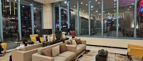 A spacious lobby with a large sofa set, a coffee table, and a rug.