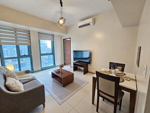 Comfort Condo | Living area | 50-inch Smart TV with digital channels, Netflix, streaming services - One Uptown Residence (Taguig)