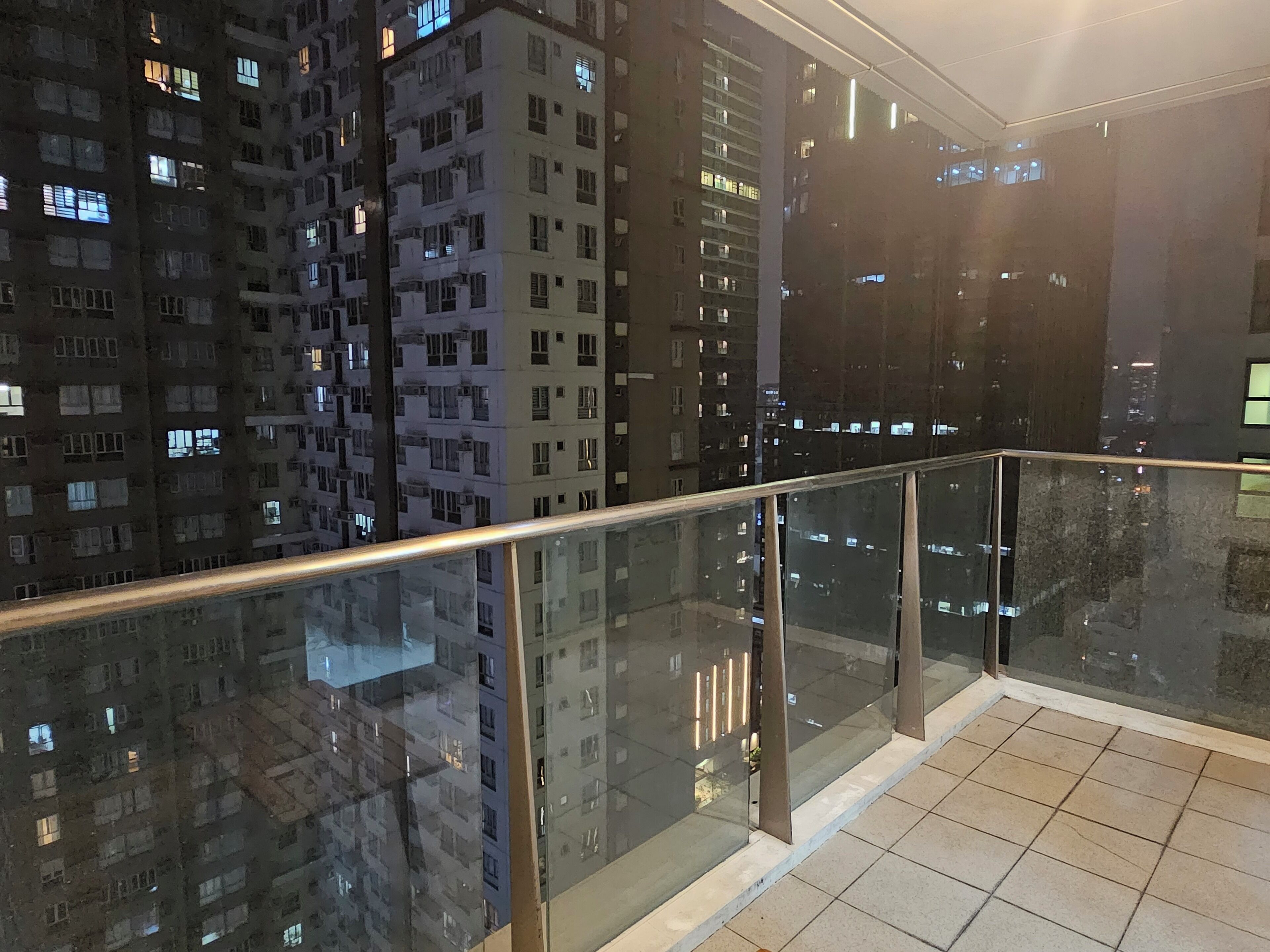 Ein Hochhaus mit mehreren Etagen, einem Glasgeländer und einem gefliesten Boden.