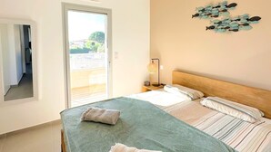 A bedroom with a bed, a nightstand, a lamp, and a wall decoration.