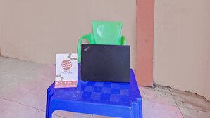 A blue plastic stool with a black laptop and a green plastic chair on top. - OYO Life 92847 Penginapan Muslim Walker (Praya)