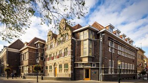 A historic building with a corner entrance, large windows, and a brick facade. - Stadsherberg Ald Weishoès (Venlo)