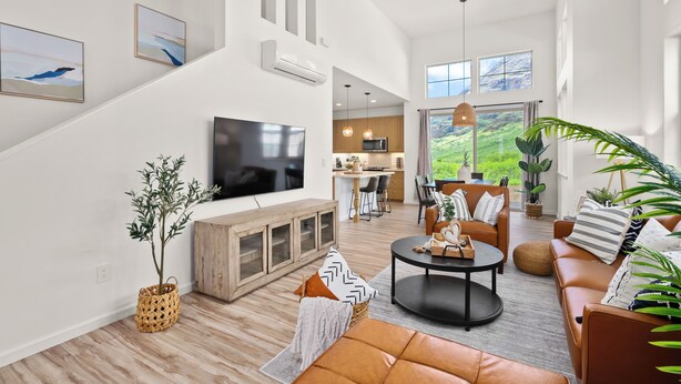 A spacious living room with a flat-screen TV, a fireplace, and a dining area with a view of the outdoors. - Mauna View by AvantStay | 10min to Beach, Backyard (Oahu)