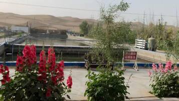 A view of a water treatment facility with industrial structures and a signboard.