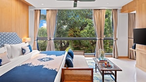 Un dormitorio con una cama grande, un sofá, una mesa de centro y un televisor.
