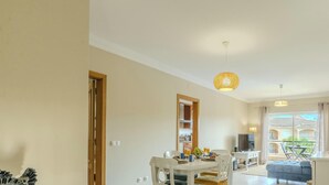 Un'ampia zona giorno con tavolo da pranzo, divano e balcone con vista.