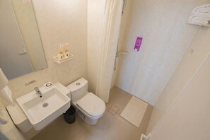 Une petite salle de bain comprenant un lavabo, des toilettes et un espace douche.