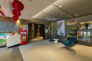 A hotel lobby with a reception desk, vending machine, seating area, and a wall with a map. - Super 8 Hotel (Suzhou Jinfeng Road Subway Station Yushan Road) (Suzhou)