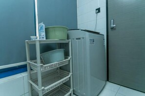 A bathroom with a grey refrigerator, a white shelf with baskets, and a blue wall. - Super 8 Hotel (Suzhou Jinfeng Road Subway Station Yushan Road) (Suzhou)