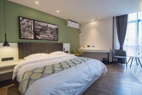 A hotel room with a bed, a desk, a chair, a picture on the wall, and a window. - Super 8 Hotel (Suzhou Jinfeng Road Subway Station Yushan Road) (Suzhou)