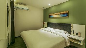 Una camera d'albergo con un letto, un comodino e un quadro appeso al muro.
