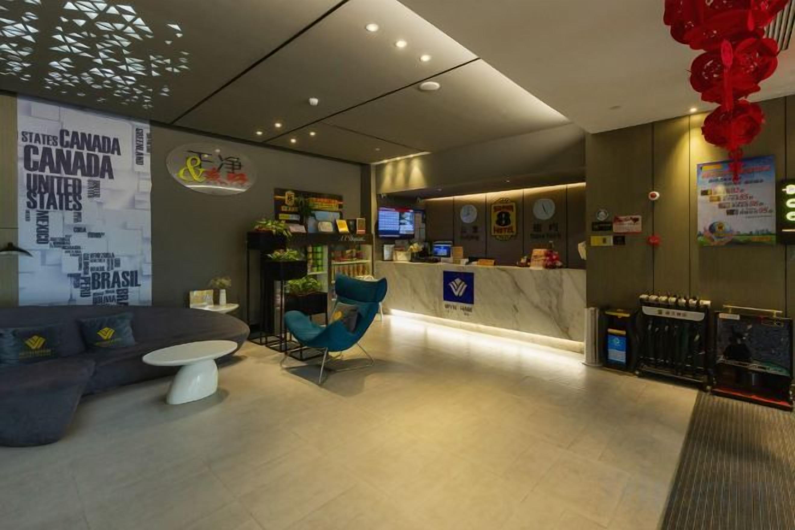 A modern lobby with a reception desk, seating area, and a wall with a map.