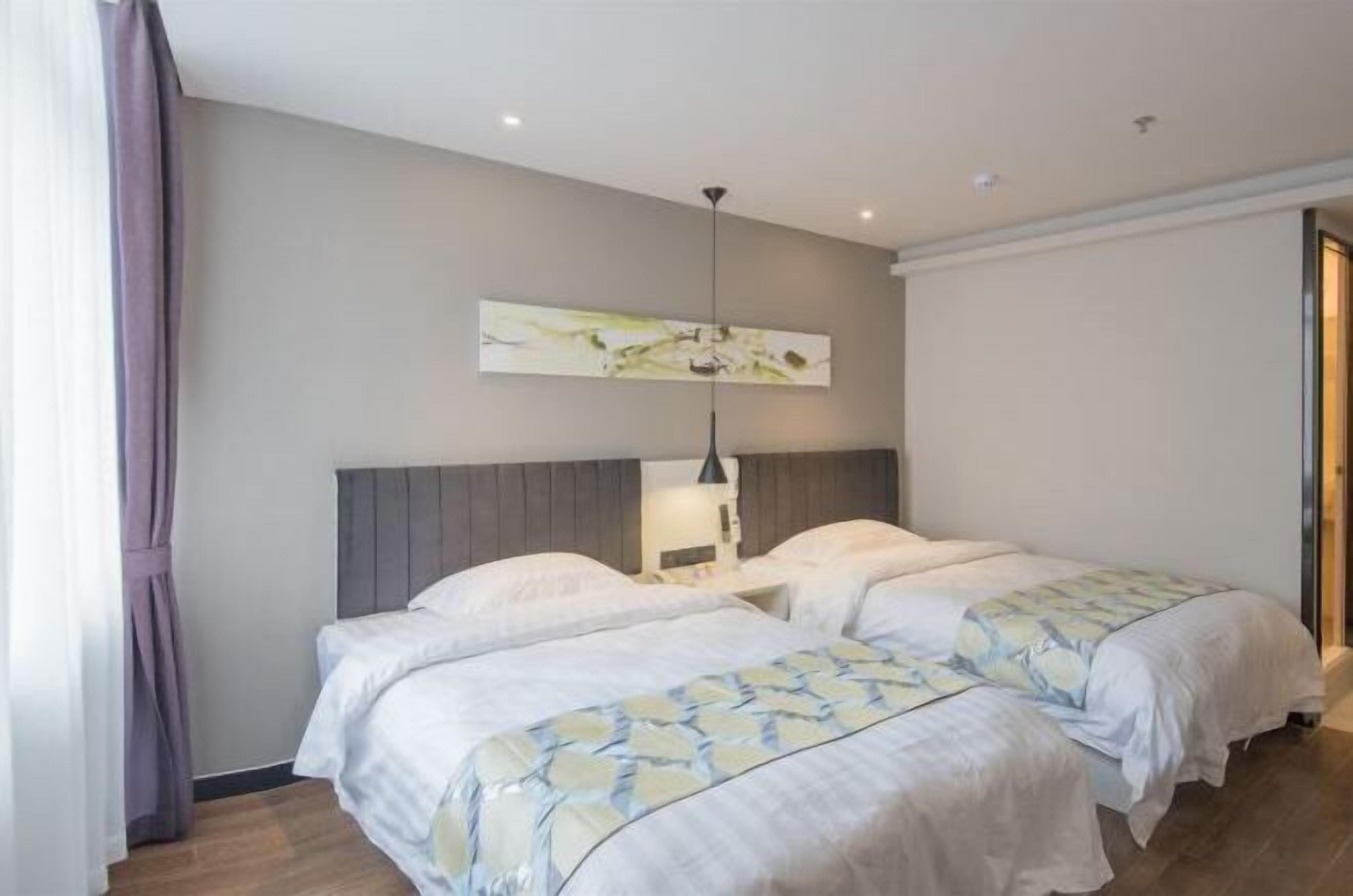 A hotel room with two beds, a modern headboard, a ceiling light, and a large abstract painting on the wall.