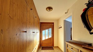 Ein Flur mit Holzausbau, einer Holztür und einem Spiegel an der Wand.