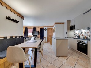 A compact living space with a dining area, a kitchen, and a small seating area.