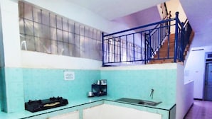 Een keuken met een blauw-wit kleurenschema, een spoelbak en een trap naar een hoger niveau.