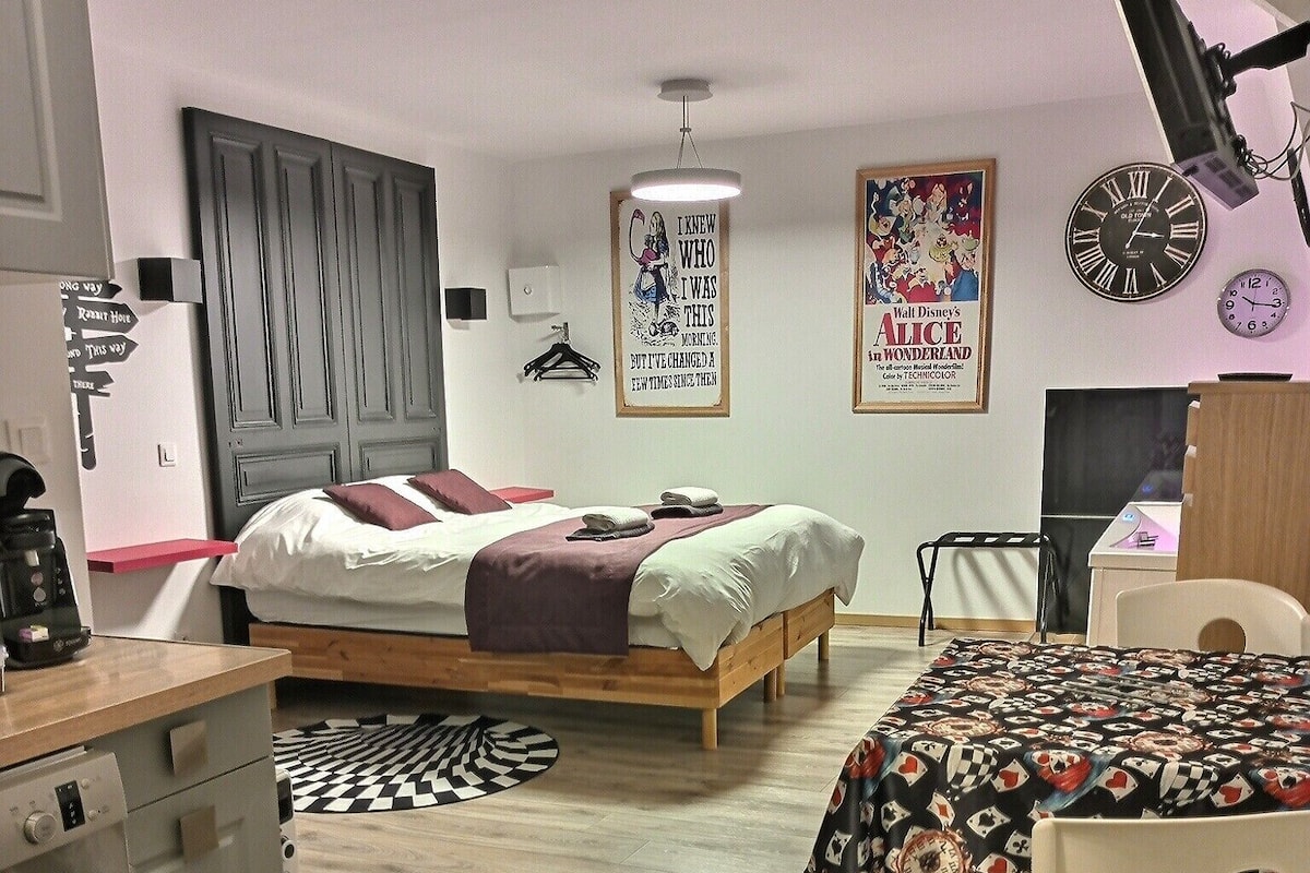 A compact bedroom with a bed, a desk, and a chair.
