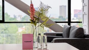A hotel room with a large window, a desk with a pink card, two bottles, and a pen. - w* | Comfy Loft near Polanco (Ciudad de México)