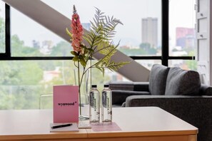 Enjoy the city view from the comfort of this stylish room, featuring a sofa and a potted plant.