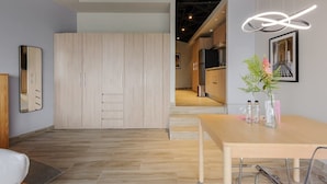 A modern kitchen with a wooden cabinet, a dining table with chairs, and a hanging light fixture. - w* | Comfy Loft near Polanco (Ciudad de México)