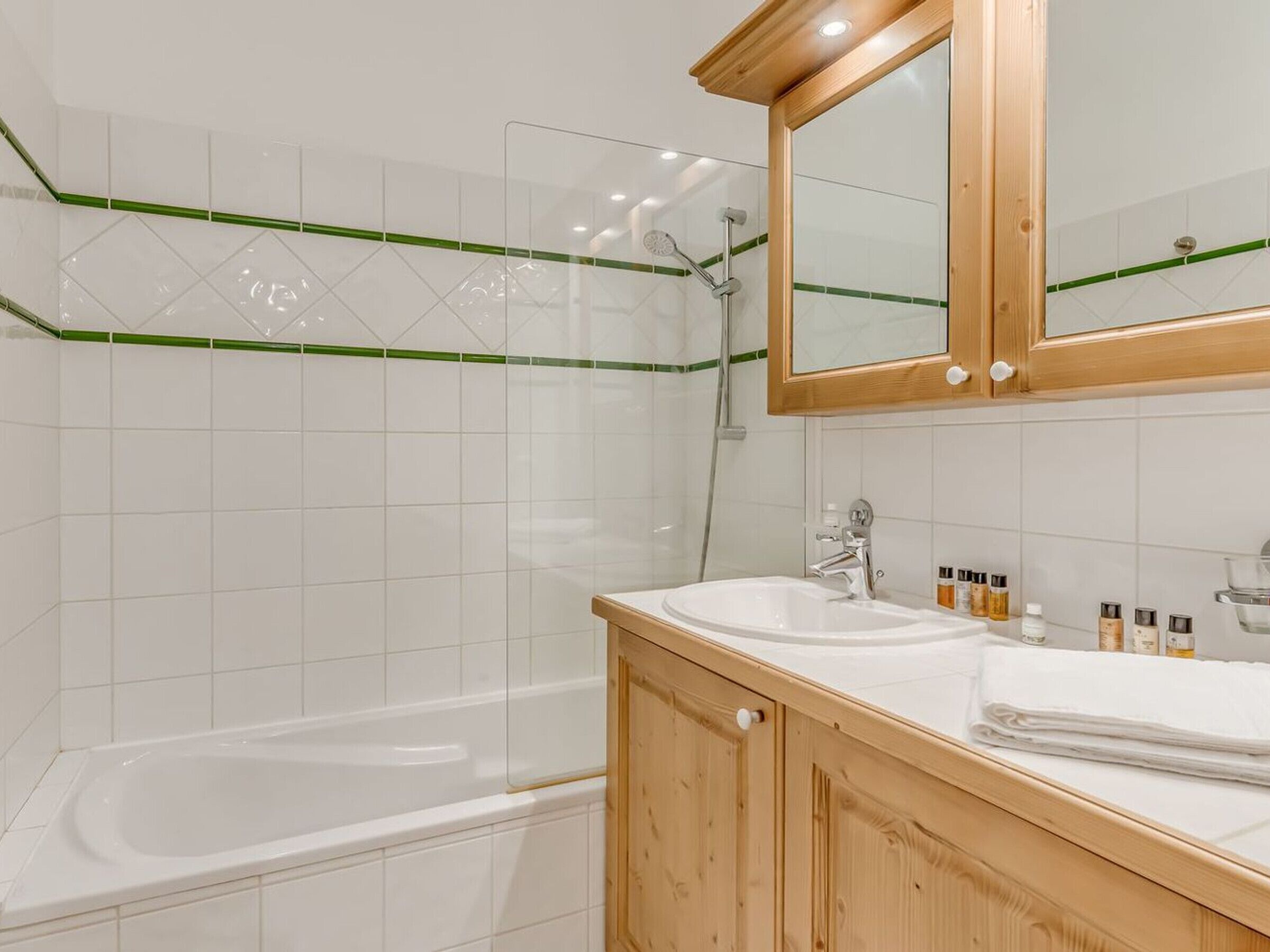 Un baño moderno con bañera, lavamanos y tocador de madera.