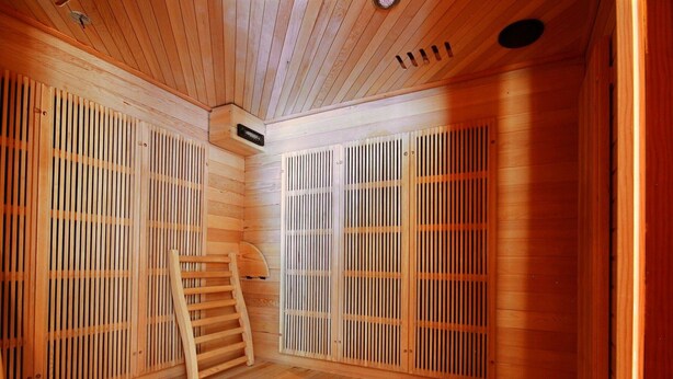 Un sauna avec des murs en bois à lattes et une échelle en bois.